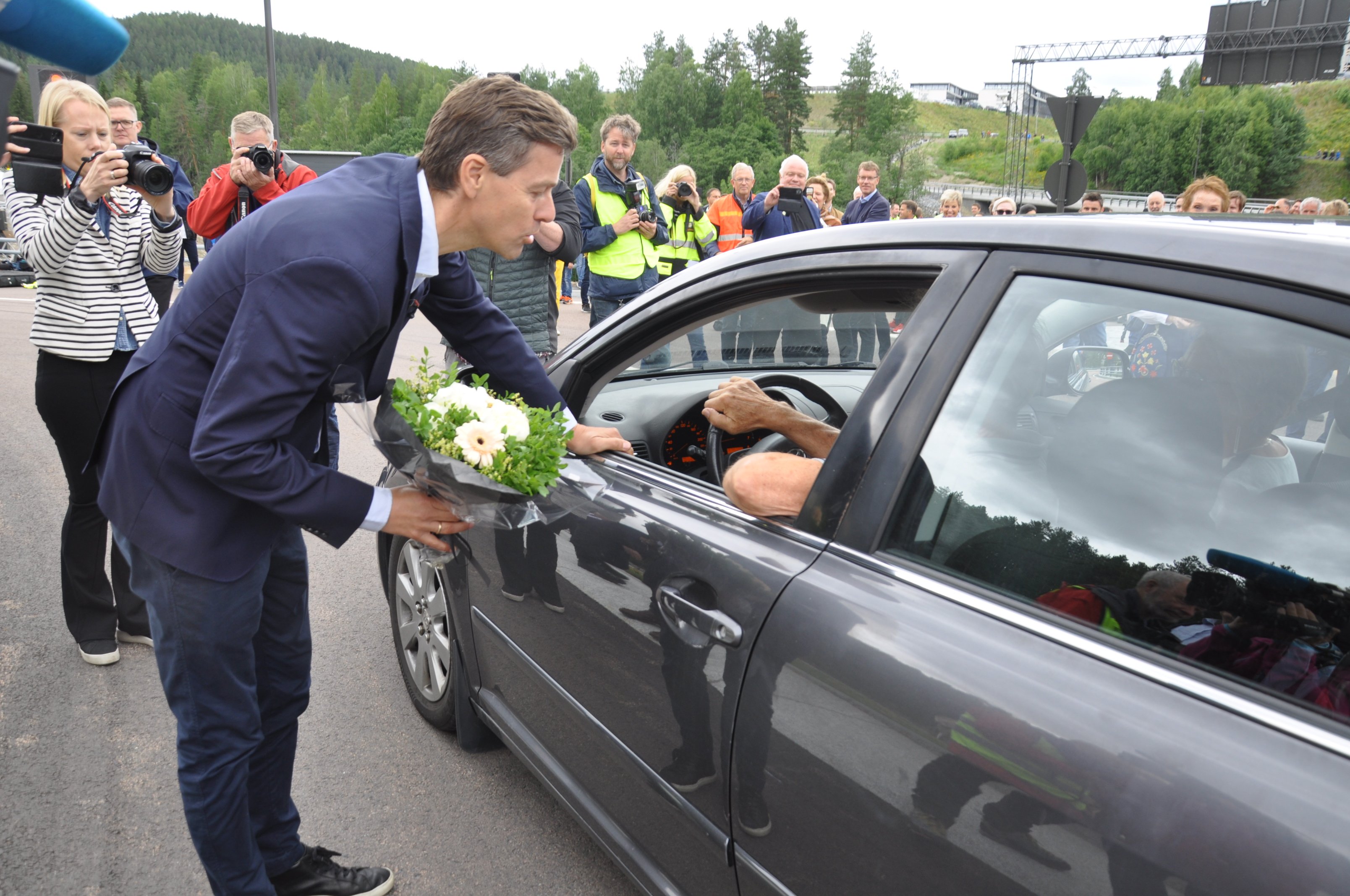 Statsråden med blomst til første bilist. (Foto: Kjell Wold)