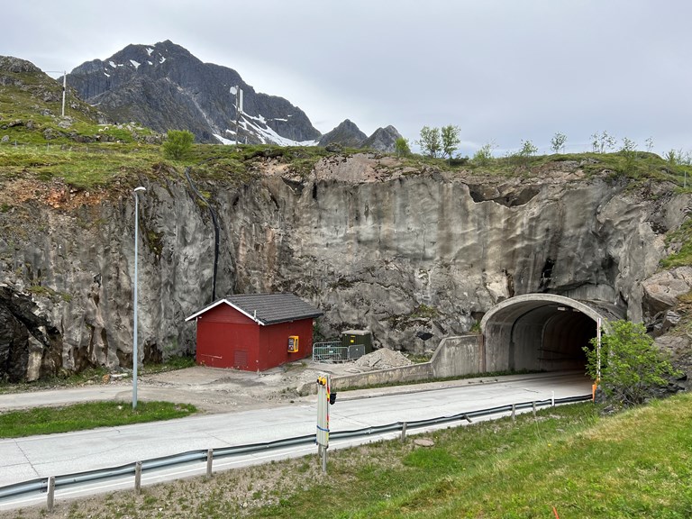 Bildet viser den sørlige tunnelportalen til Nappstraumtunnelen som kommer opp av bakken på Flakstadøya i Lofoten.