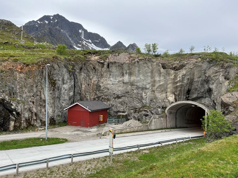 Bildet viser den sørlige tunnelportalen til Nappstraumtunnelen som kommer opp av bakken på Flakstadøya i Lofoten.