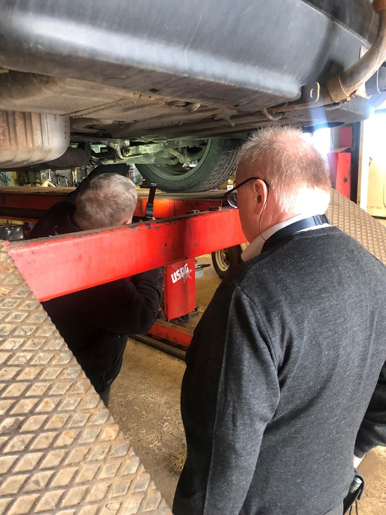 Inspektør fra Statens vegvesen som kontrollerer hvordan en mekaniker ved et verksted har gjennomført EU-kontroll - bilde