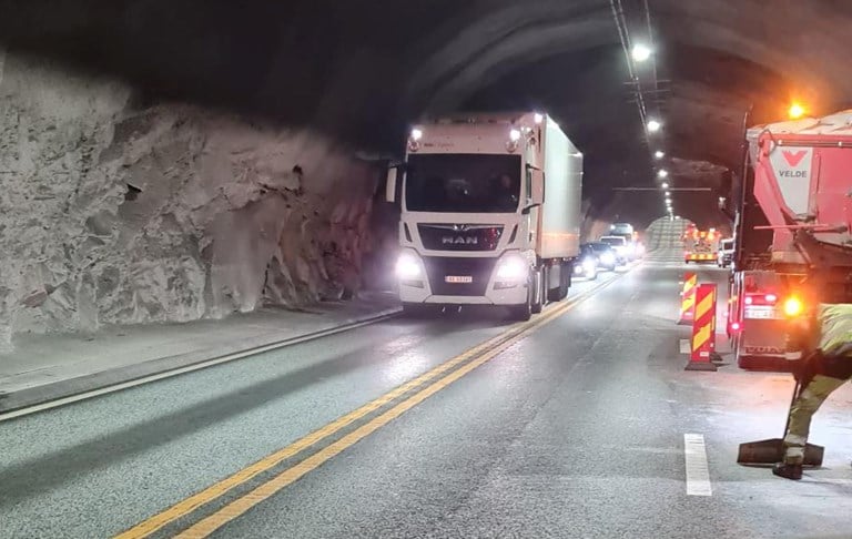 Bilete av ein lastebil som køyrer gjennom ein tunnel. Fleire bilar følgjer etter. Eitt felt i motsett køyreretning er stengd av på grunn av vegarbeid.