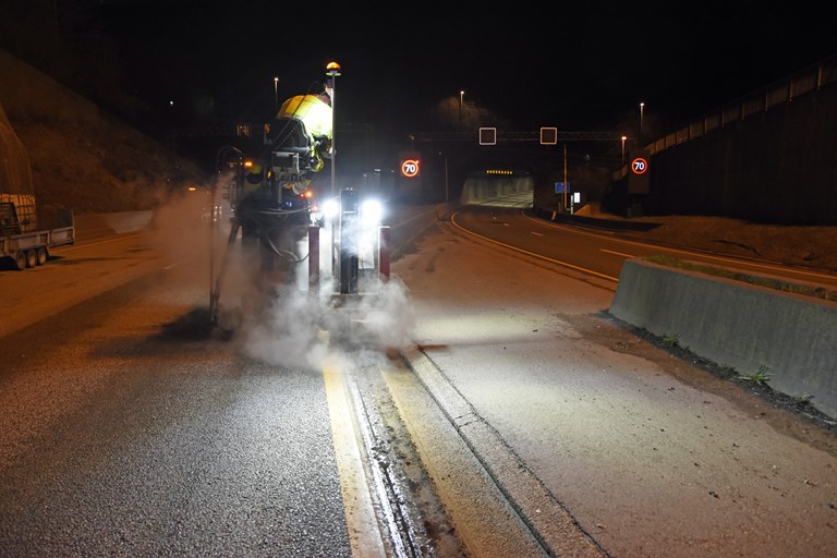 Entreprenør klargjør for å legge ned fiberkabel i asfalten i og ved Lyderhorntunnelen, for å teste ut ny teknologi som skal gi bedre trafikkovervåkning. 