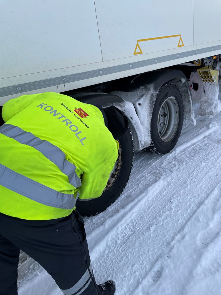 Kontrollør fra Statens vegvesen undersøker dekk på en lastebil - illustrasjonsfoto