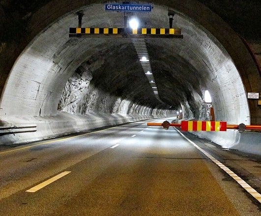 Bilde av tunnel med bom i kveldsbelysning.