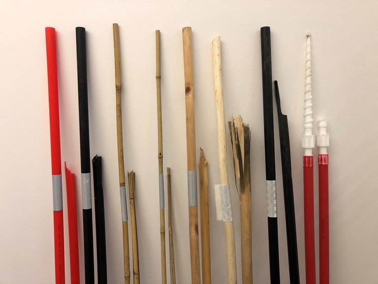 Brøytestikkene som er testet. Hele ved siden av de som er knekt etter stor belastning, for å se hvordan skaden blir. Fra venstre: rød plast, svart plast, tykk bambus, tynn bambus, furu, pil, svart plast med riller, skrubrøytestikke.
