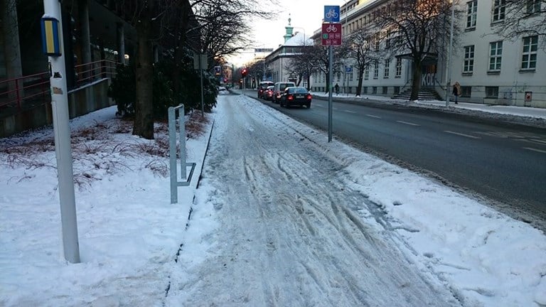 FIgur 15 er et foto av sykkelvei med løs og våt snø.