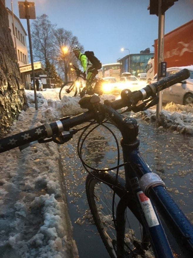 Figur 18 er et foto av syklister som ikke kommer forbi snøranken på en sykkelsti.