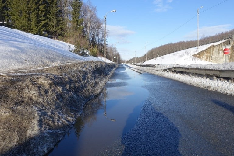 Figur 20 er et foto av en gang- og sykkelvei med vanndammer på vinteren.