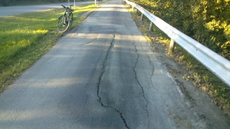 Figur 26 er et foto av en gang- og sykkelvei med langsgående sprekker.