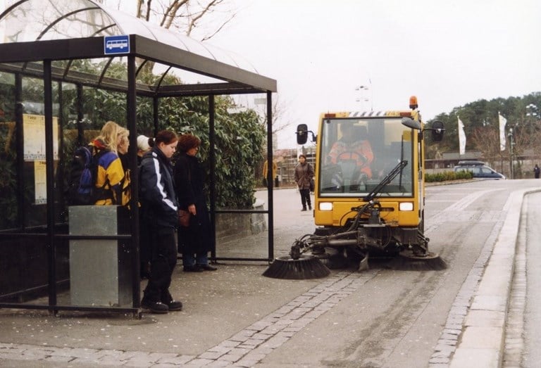 Figur 34 er et foto av en feiemaskin ved en bussholdeplass.