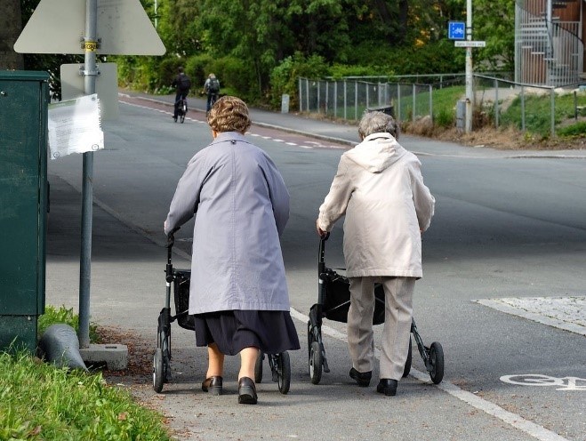 Figur 8 er et foto av to personer med rullator på en gang- og sykkelvei.