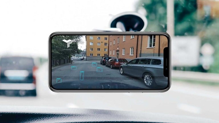 Bilde av mobil montert i frontruta på ein bil. 