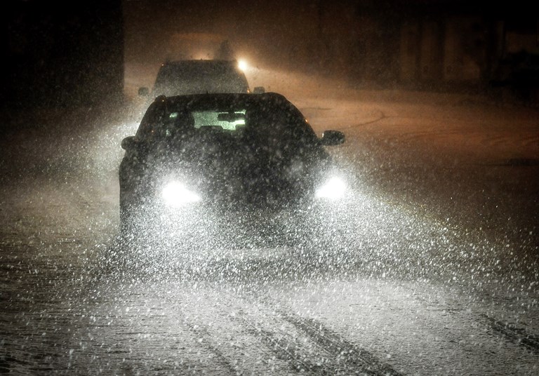 Bilde av bil i mørke og snøfokk