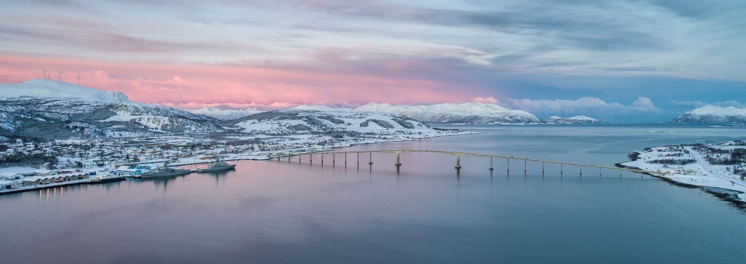 Solnedgang over fjord og bru