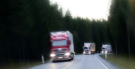 Lastebiler kjører på en større vei.