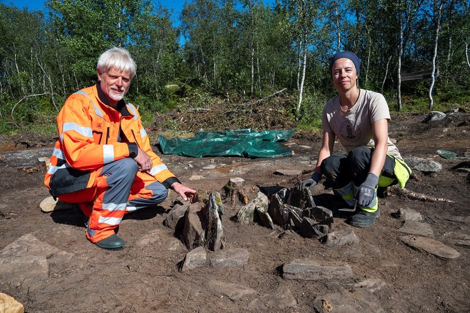 Byggeleiar Frode Lykkebø og arkeolog Christine Tøssebro sitter ved ein av omnane som ble brukt til å utvinne jern for 1000 til 1500 år sidan - bilde