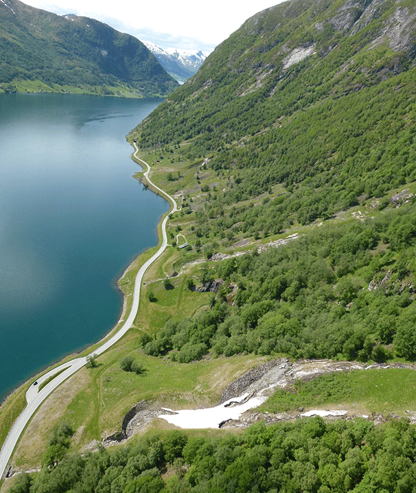 Eksisterande veg langs Kjøsnesfjorden med fleire rasløp nedetter fjellsida.